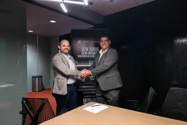 Professional handshake after closing an NWX Consorcio agreement
